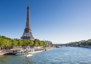 Eiffelturm an der Seine, mit grünen Ufern, klarem Himmel und vorbeifahrenden Booten