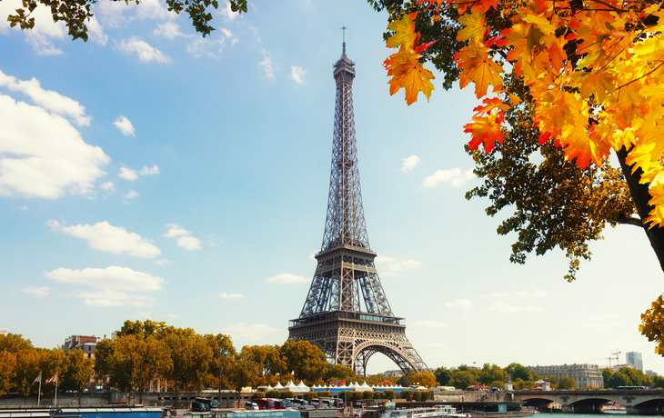 Eiffelturm und Seine mit Booten an einem sonnigen Tag in Paris.